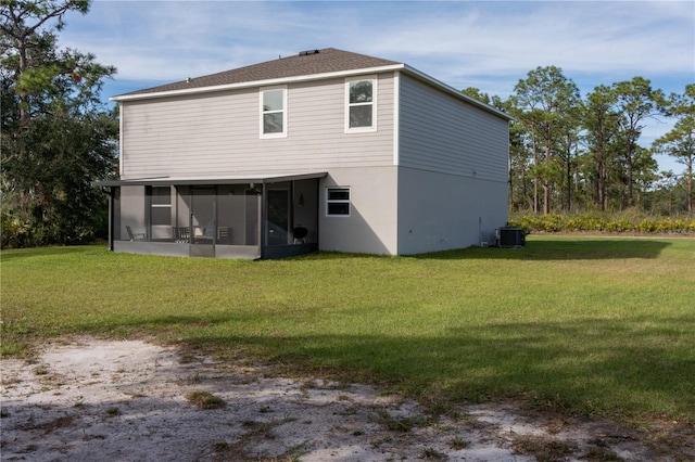 back of property featuring central air condition unit, a lawn, and a sunroom