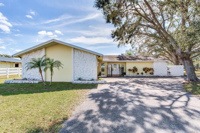 single story home featuring a front lawn