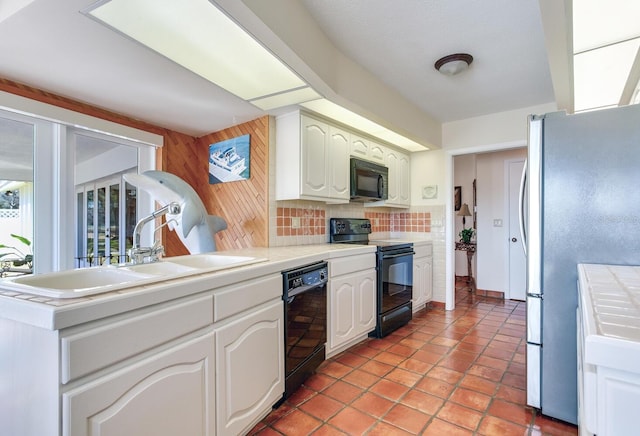 kitchen with sink, white cabinetry, tasteful backsplash, black appliances, and tile countertops