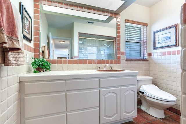 bathroom featuring tile walls, vanity, toilet, and walk in shower