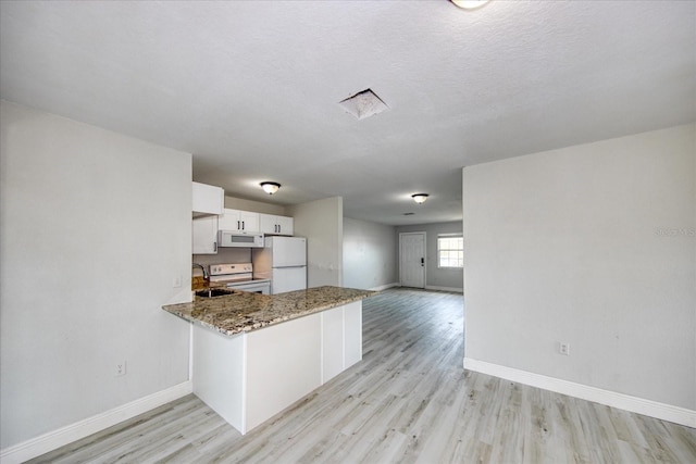 kitchen featuring kitchen peninsula, white appliances, light hardwood / wood-style flooring, white cabinets, and dark stone counters