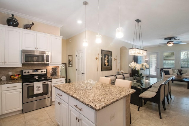 kitchen with white cabinetry, stainless steel appliances, tasteful backsplash, a kitchen island, and decorative light fixtures