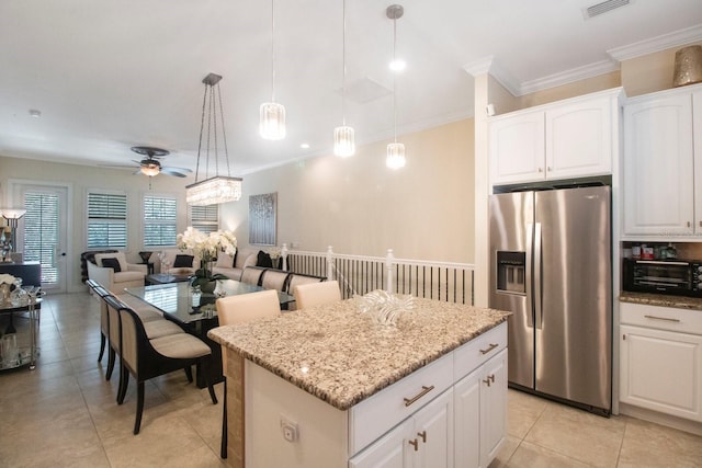 kitchen featuring a kitchen island, white cabinetry, stainless steel fridge, hanging light fixtures, and light stone countertops