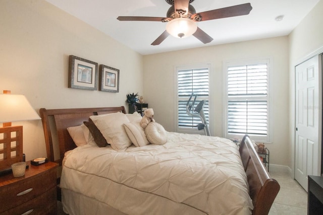 tiled bedroom featuring ceiling fan and a closet