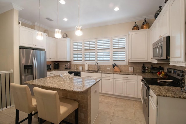 kitchen with sink, white cabinetry, hanging light fixtures, stainless steel appliances, and a center island