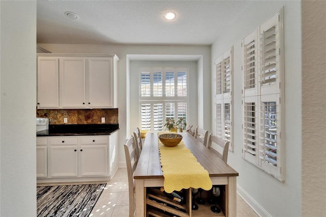 dining area featuring light tile patterned flooring and a textured ceiling