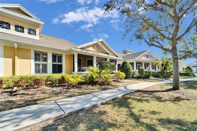 view of front of property with covered porch and a front lawn