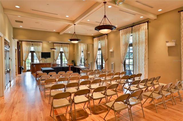 interior space with light wood-type flooring, beam ceiling, and coffered ceiling