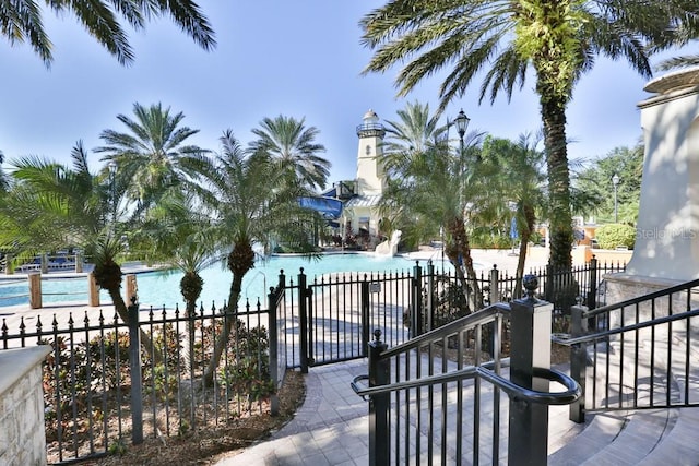 view of gate featuring a community pool and pool water feature