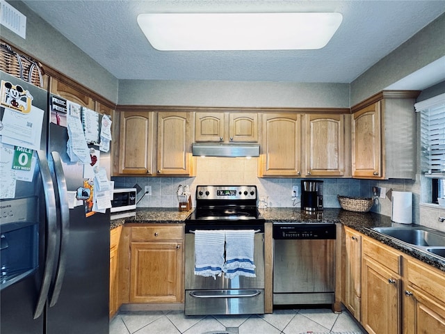 kitchen featuring sink, backsplash, light tile patterned floors, and appliances with stainless steel finishes