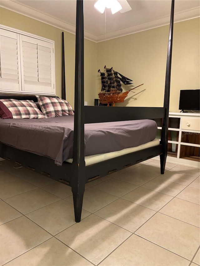 bedroom with crown molding, ceiling fan, and light tile patterned floors