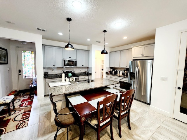 kitchen with backsplash, appliances with stainless steel finishes, sink, and gray cabinets