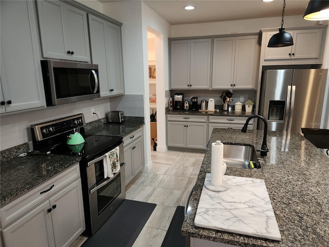 kitchen with backsplash, appliances with stainless steel finishes, and dark stone counters