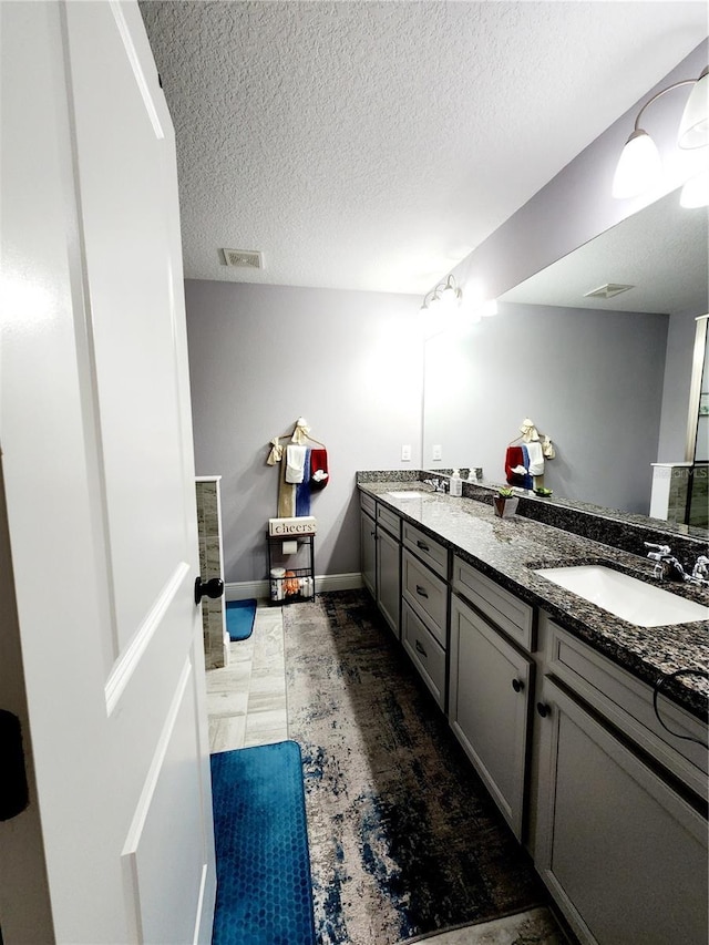 bathroom featuring a textured ceiling and vanity