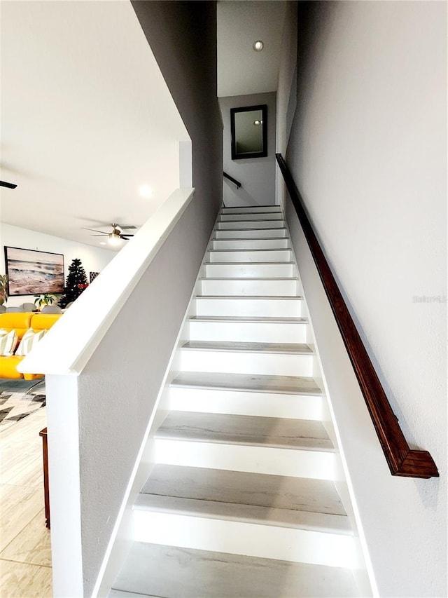 staircase featuring ceiling fan