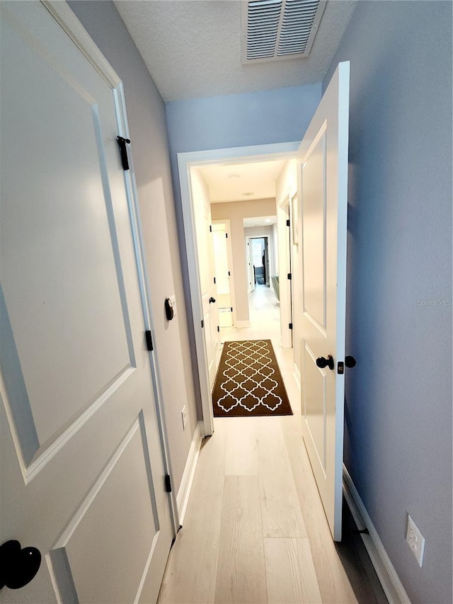 hallway with light hardwood / wood-style flooring