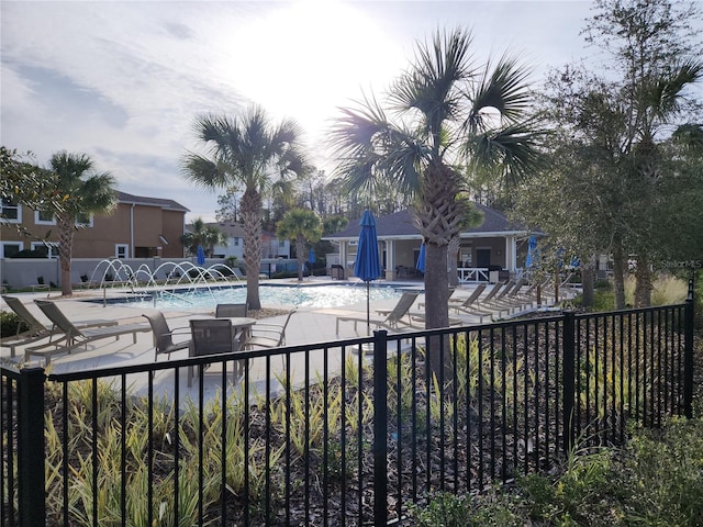 view of swimming pool with pool water feature and a patio area