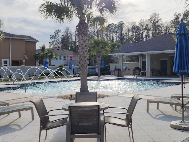 view of swimming pool featuring pool water feature and a patio