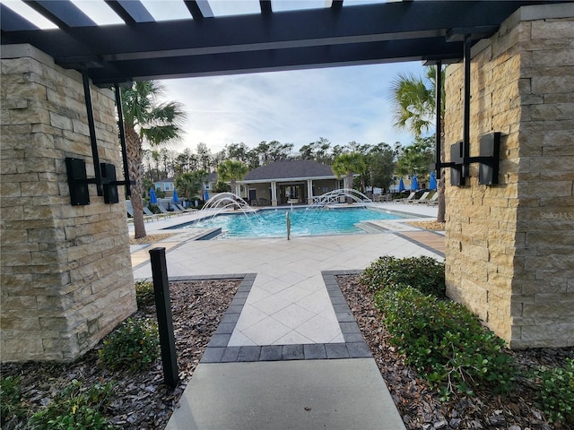 view of pool featuring a patio area, an outbuilding, and pool water feature