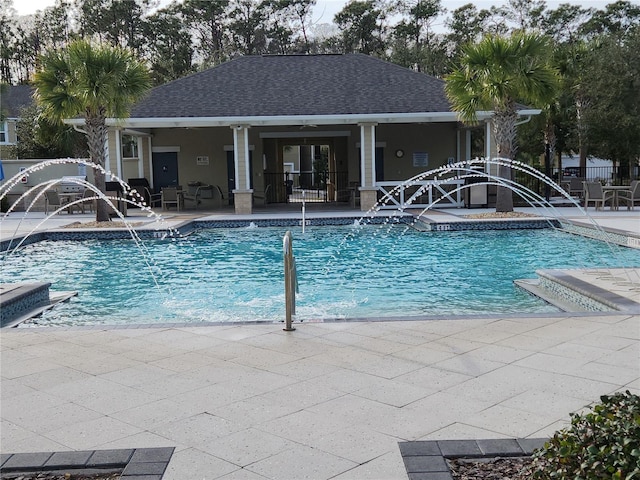 view of swimming pool with pool water feature and a patio