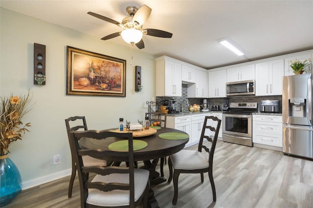 kitchen featuring decorative backsplash, white cabinetry, appliances with stainless steel finishes, and light hardwood / wood-style flooring