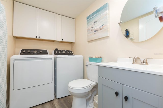 bathroom featuring hardwood / wood-style floors, vanity, separate washer and dryer, and toilet