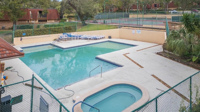 view of swimming pool with a hot tub and a patio area