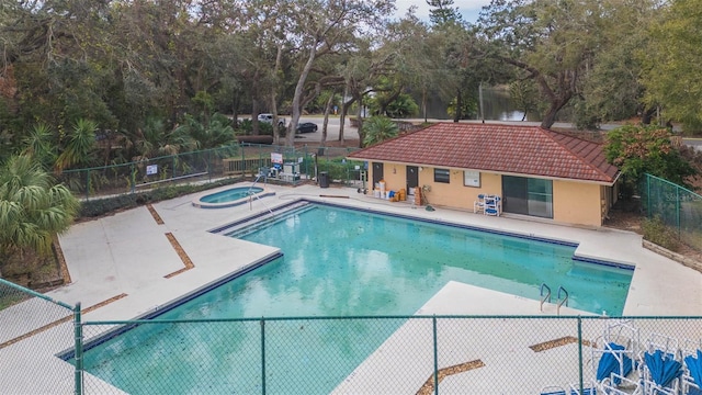 view of pool featuring a hot tub and a patio area