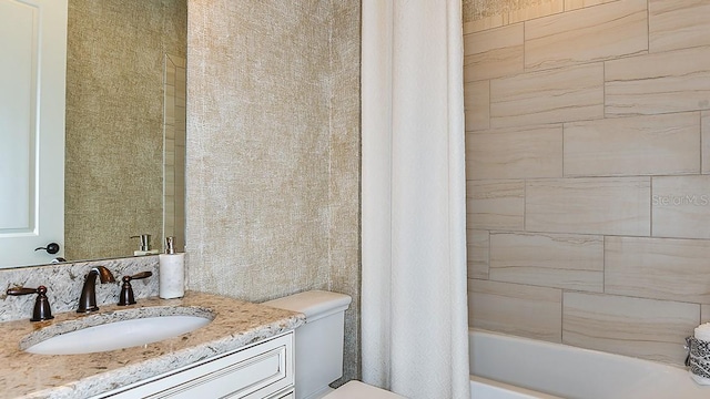 full bathroom featuring shower / bath combo, vanity, and toilet