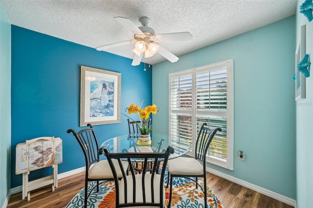 dining room featuring ceiling fan, dark hardwood / wood-style flooring, and a textured ceiling