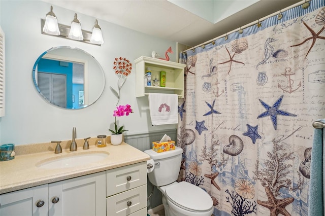 bathroom featuring curtained shower, vanity, and toilet