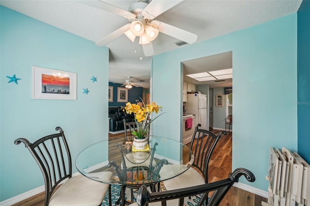 dining area featuring radiator, ceiling fan, a textured ceiling, and hardwood / wood-style flooring