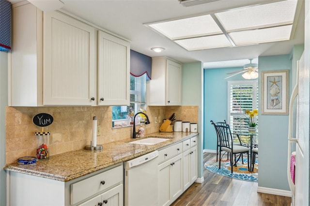 kitchen featuring backsplash, sink, wood-type flooring, dishwasher, and white cabinetry