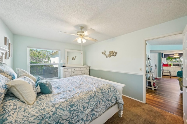 carpeted bedroom with ceiling fan and a textured ceiling