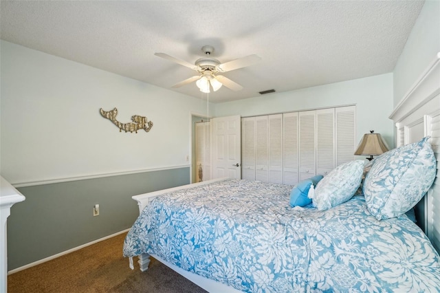 bedroom featuring ceiling fan, a closet, carpet floors, and a textured ceiling