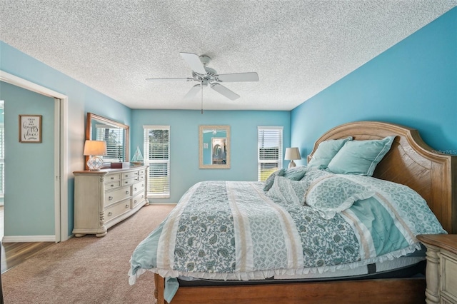 bedroom featuring light carpet, a textured ceiling, and ceiling fan