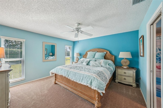 bedroom featuring carpet, a textured ceiling, multiple windows, and ceiling fan