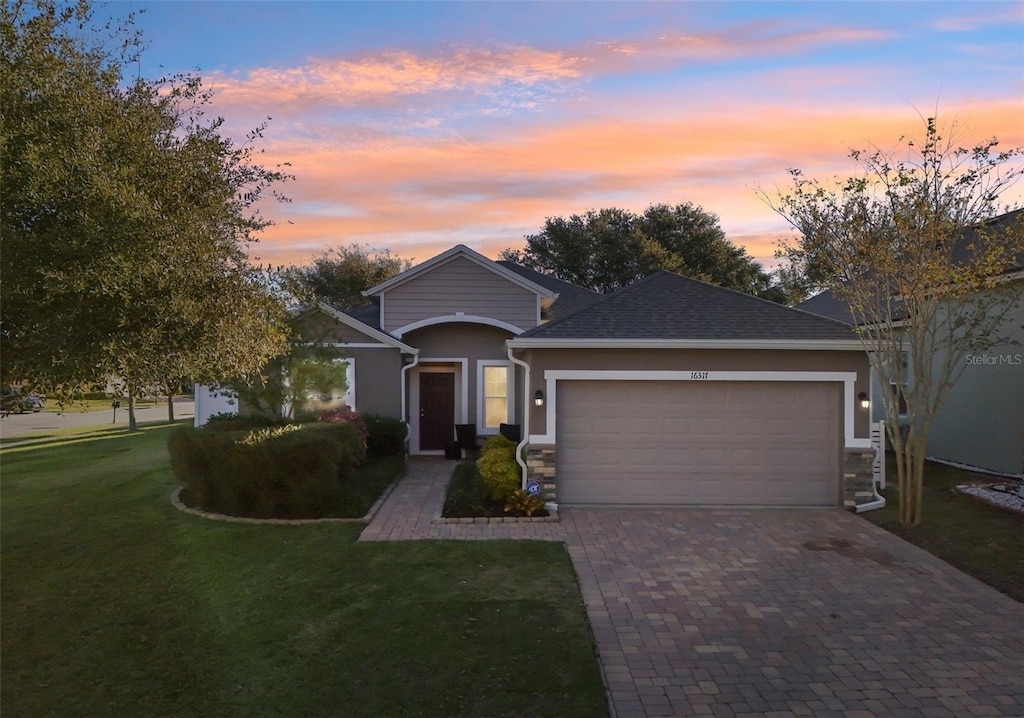 view of front of house featuring a garage and a yard