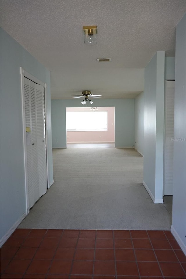 hallway with carpet and a textured ceiling