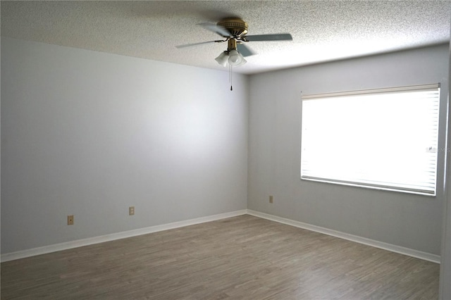 empty room featuring a textured ceiling, dark hardwood / wood-style flooring, and ceiling fan