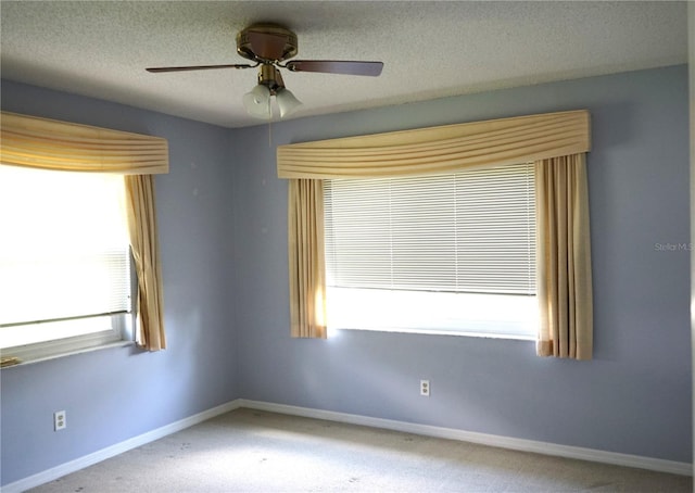 unfurnished room with carpet, a textured ceiling, plenty of natural light, and ceiling fan