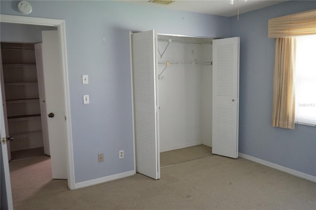 unfurnished bedroom with light colored carpet and multiple windows