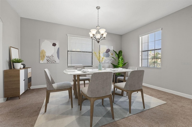 carpeted dining space featuring a notable chandelier