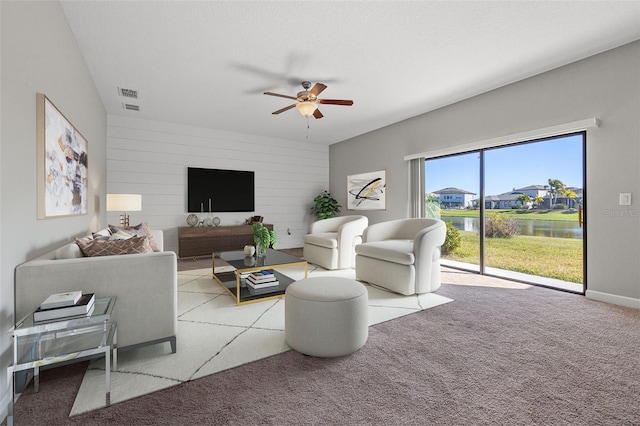 living room with light carpet, a textured ceiling, and ceiling fan