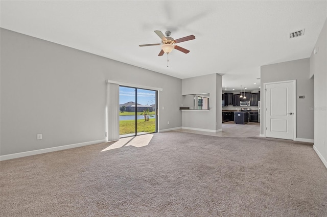 unfurnished living room with ceiling fan and light colored carpet