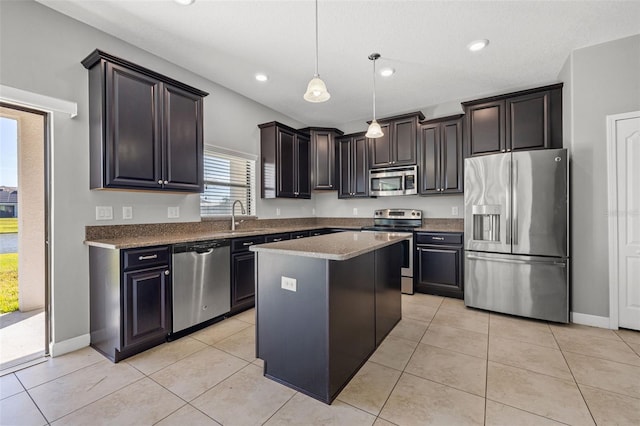 kitchen featuring pendant lighting, sink, light tile patterned floors, appliances with stainless steel finishes, and a kitchen island