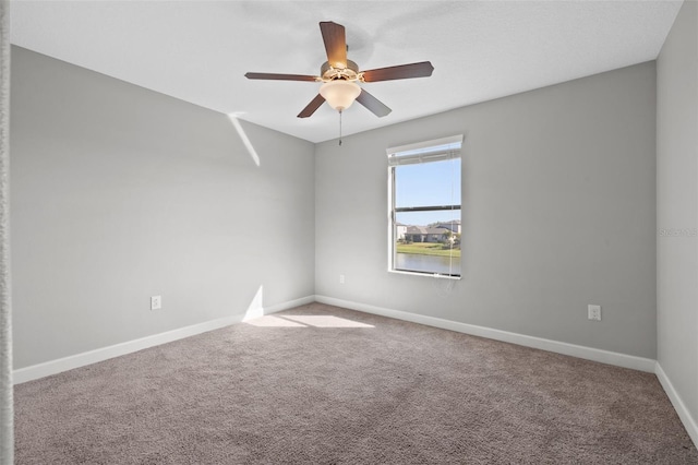 carpeted spare room featuring ceiling fan