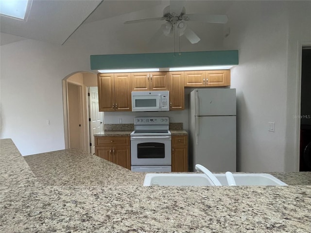 kitchen with white appliances, lofted ceiling, sink, ceiling fan, and washer / dryer