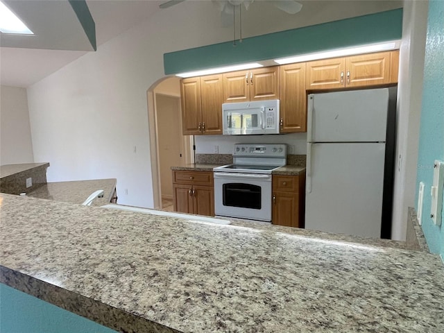 kitchen featuring ceiling fan, white appliances, kitchen peninsula, and lofted ceiling