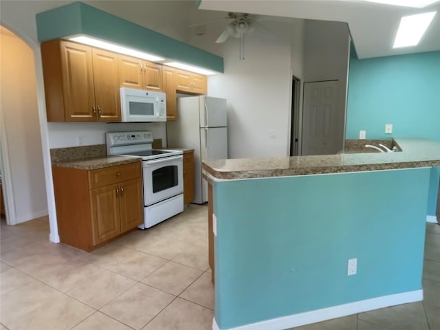 kitchen with kitchen peninsula, ceiling fan, light tile patterned floors, and white appliances